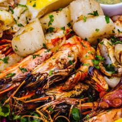 158966045-seafood-platter-grilled-lobster-shrimps-scallops-langoustines-octopus-squid-on-white-plate